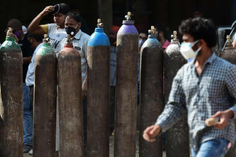 People wait to refill oxygen cylinders for Covid-19 coronavirus patients in Allahabad on April 24, 2021.