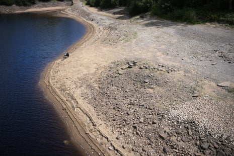 A man fishes from the dried out bed of Ladybower Reservoir in the Derwent Valley in Bamford, England.