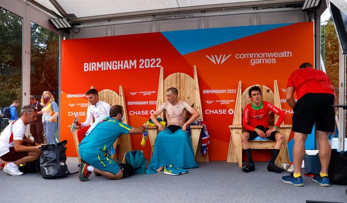 Australia’s gold medallist Rohan Dennis (centre) is seen alongside England’s silver medallist England’s Fred Wright (left) and bronze medallist Geraint Thomas of Wales as they take a breather before the medal ceremony.