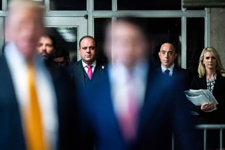 a line of people watch as a man speaks