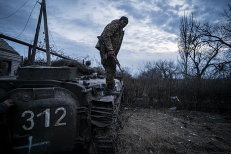 A member of Ukrainian service personnel stands by a tank along the frontline north of Bakhmut.