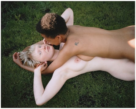 Two naked women embracing on the grass