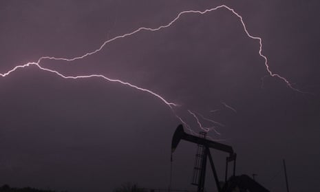 Lightning stretches across the sky in west Texas, with an oil derek in the foreground.