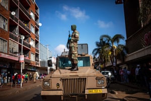 A member of the South African National Defence Force stands on a military vehicle during a lockdown patrol, Johannesburg, South Africa