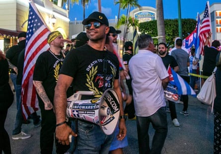 Man wears megaphone in crowd of those holding US flag