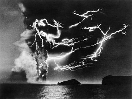 A black-and-white photo of huge streaks of lightning against a black cloud of smoke