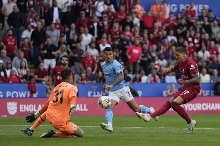 Darwin Nunez, Liverpool player, kicks a ball into the goal, which is Ederson, Manchester City goalkeeper.