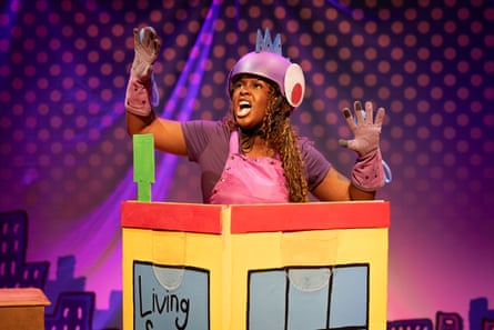Female actor in military or bike helmet inside a cardboard house and singing