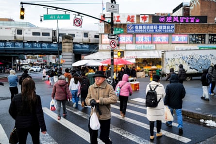 People at a street intersection with many signs in Chinese.