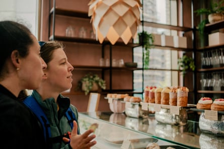 يقفون عند الطاولة الزجاجية، ينظرون إلى المنتجات المخبوزة