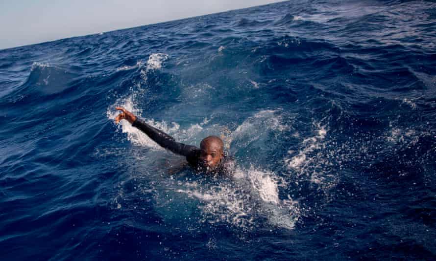 A migrant tries to board a boat belonging to the German NGO Sea-Watch in the Mediterranean, 2017