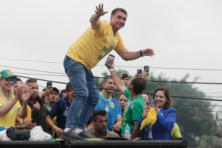 Flávio Bolsonaro balances on open-top bus