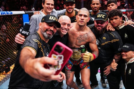 crowd of men gather in fighting ring to take selfie