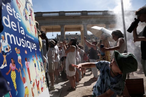 People cool off under a mist sprayer