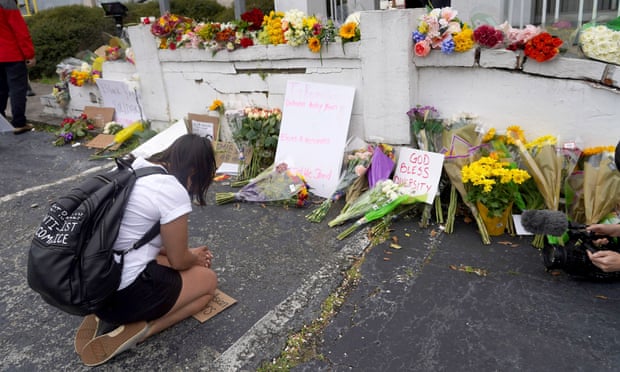 A person kneels in front of a makeshift memorial outside Gold Spa in Atlanta, Georgia, on 18 March. 