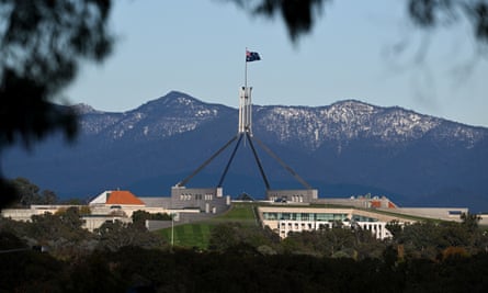 Parliament House in Canberra against a backdrop of snow capped mountains