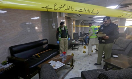 Police officers examine the crime scene after the shooting incident on the premises of the Peshawar high court