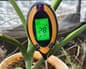 Close-up image of potted house plant with moisture meter stuck in the plant pot soil.