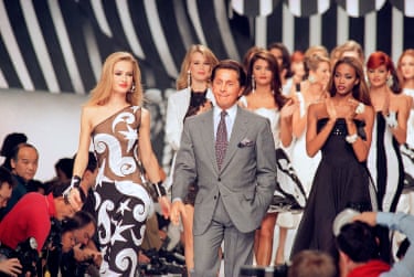Valentino walks the catwalk with his models after a fashion show in Paris in 1991
