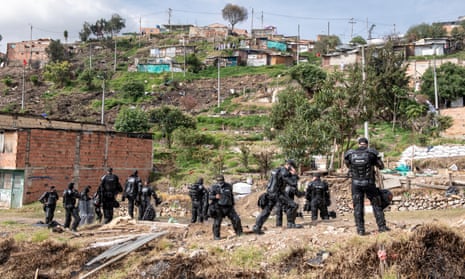 A group of riot police is waiting orders to position themselves inside the slum of Altos de la Estancia on 11 May. During the past days, several evictions were processed, and the houses destroyed. 