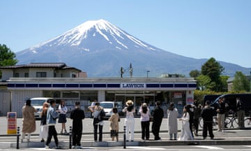 Tourists at the Lawson convenience store in  Fujikawaguchiko taking pictures of Mount Fuji.