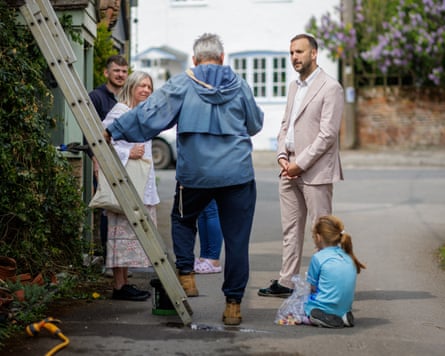 Zack Polanski talks to a family in a village street