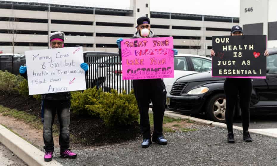 People hold signs at an Amazon building in Staten Island, New York, on 30 March. 