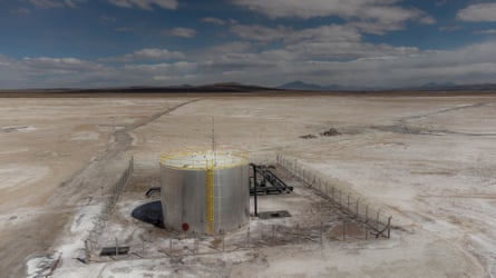 A large cylindrical container surrounded by a fence on a salt flat