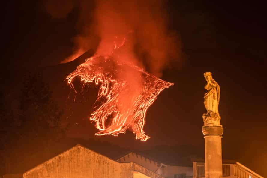 The statue of Virgin Mary near the main church of Milo with the lava flow of an eruption