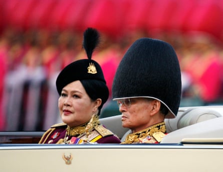King Bhumibol reviews a parade with Queen Sirikit to mark his birthday in Bangkok in 2006.