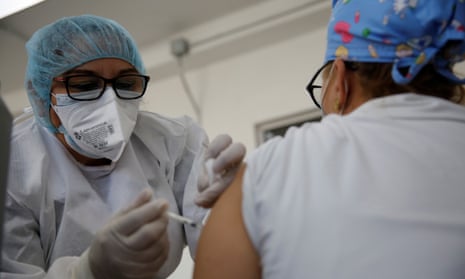 A nurse in Mejicanos, El Salvador, gives the Covid-19 vaccine to a healthcare worker on 12 March.