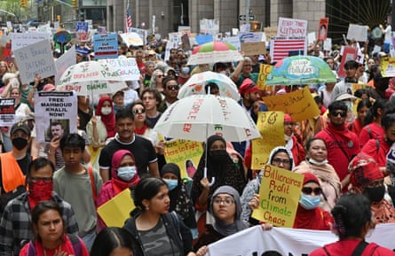 a group of people in streets hold signs such as ‘billionaires profit from climate chaos’ and ‘stop pollution’