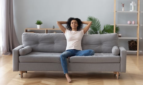 Calm black woman relaxing on comfortable sofa in living roomYoung calm black woman relaxing sit on comfortable sofa in modern living room, lazy happy african woman girl resting on couch breathing fresh air enjoy peace of mind no stress free on couch at home