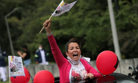 A woman holding a flag protests from a car due to the ongoing Covid-19 outbreak, during a national strike, in Bogotá, Colombia.