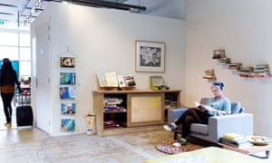 A woman sits reading a book in the communal lobby area of Econama Amsterdam