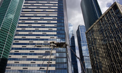 Debris is cleared at a building damaged by drones in Moscow on Sunday