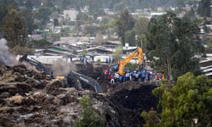 Police and rescue workers watch as excavators dig in search of missing people at the Reppi rubbish dump in Addis Ababa