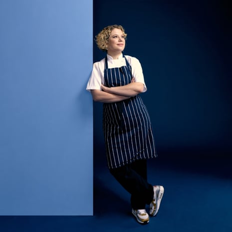 Sally Abé leaning in chef's striped apron