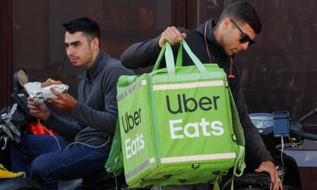 Uber Eats workers wait for orders in central Kiev, Ukraine. Is delivering takeouts the way forward for the company?