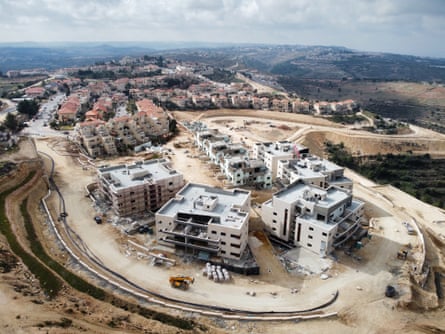 Aerial view of blocks of flats being constructed on a hilltop.