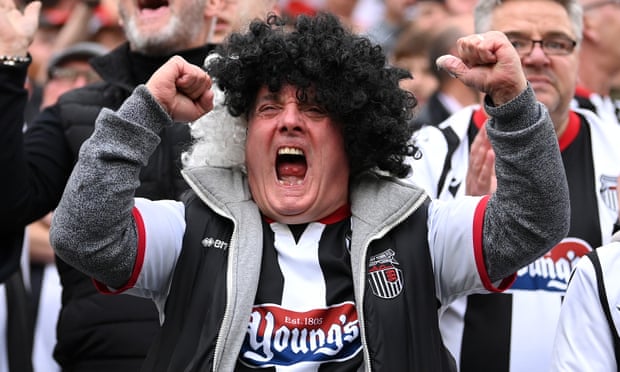 A Grimsby fan celebrates after the club won the Vanarama National League final.