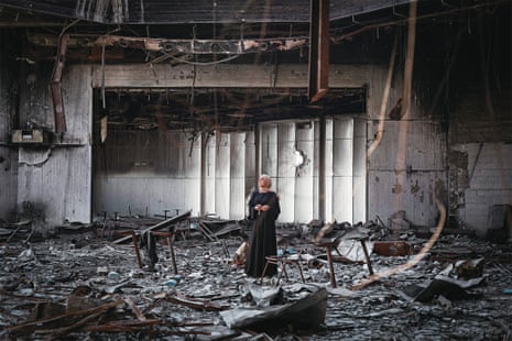 A woman stands in a ruined building in Gaza
