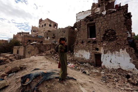 Yemeni girls stand near a building destroyed by an airstrike, in the old city of Sana’a, Yemen