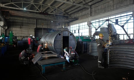 Workers weld and cut metal as they build a shelter.
