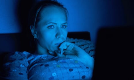 A woman looking at her laptop in the dark