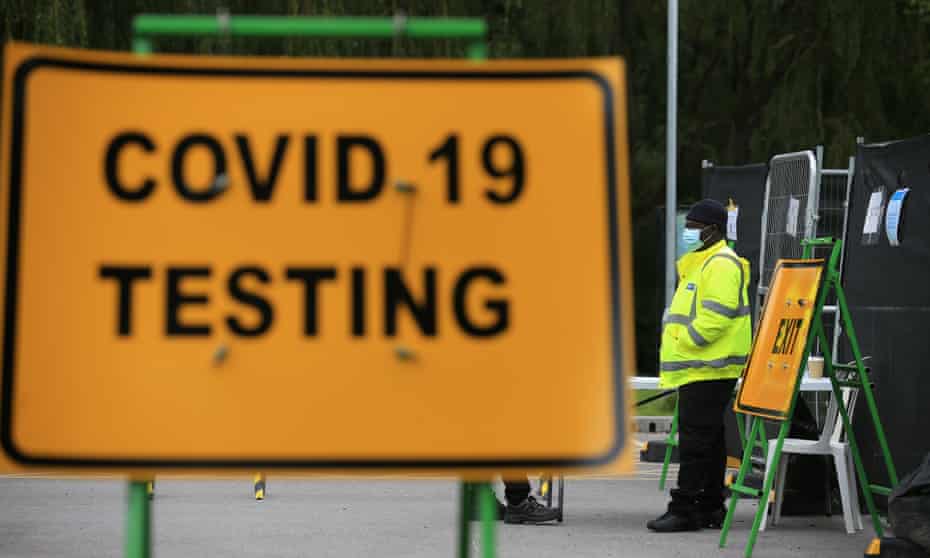 Security guards stand on duty at a novel coronavirus COVID-19 testing centre in Stockport, northwest England