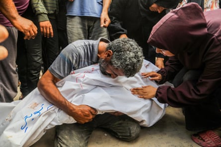 A man hugs the body of a dead loved one