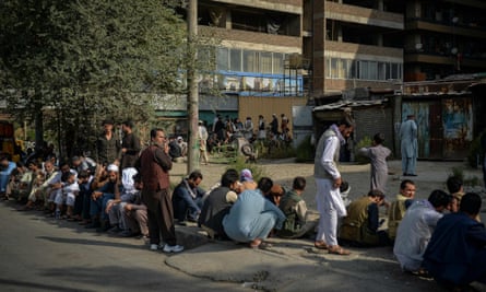 Afghans queue up as they wait for the banks to open and operate at a commercial area of Kabul.