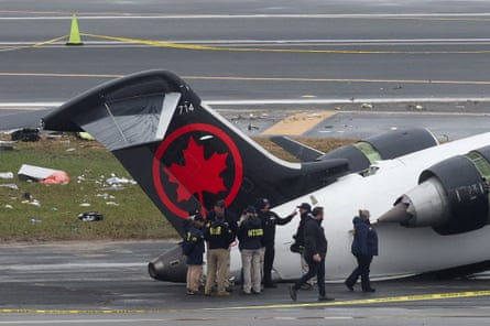 people stand outside of plane with debris on ground
