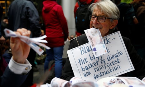A protester eats fake money outside the BlackRock office during an Extinction Rebellion demonstration in the City of London in October.